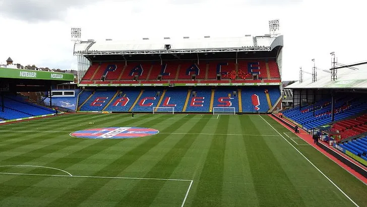 Góc nhìn cận cảnh bên trong sân vận động Selhurst Park, với hàng ghế khán giả và mặt cỏ sân đấu