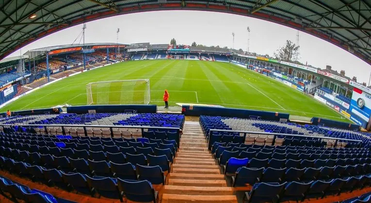 Góc nhìn tổng thể trận đấu từ khán đài sân Kenilworth Road, mang lại cái nhìn chân thực về không gian và tầm nhìn từ vị trí người hâm mộ.