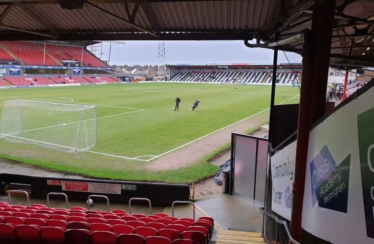 Góc nhìn từ khán đài bên trong sân vận động Blundell Park, cho thấy tầm nhìn ra sân cỏ và cấu trúc các khu vực ghế ngồi