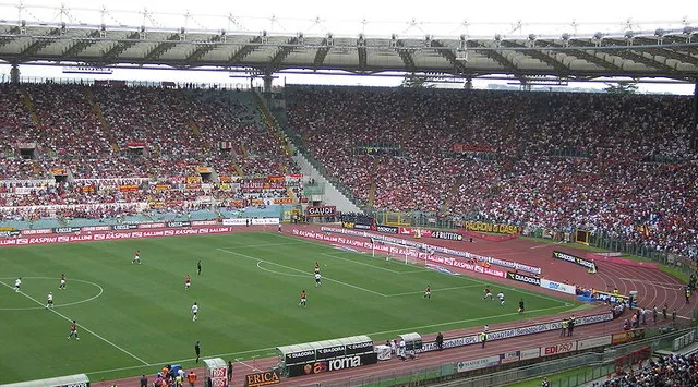 Một trận đấu của AS Roma đang diễn ra tại Stadio Olimpico, với khán giả lấp đầy khán đài